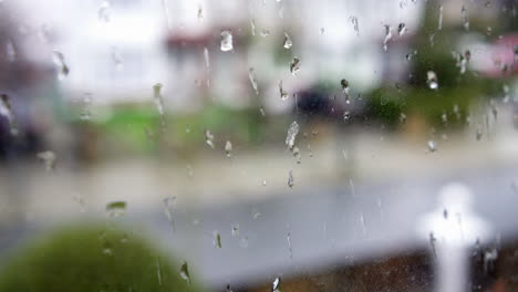 Regentropfen-Auf-Einem-Fenster-Mit-Blick-Auf-Eine-Straße-Mit-Vorbeifahrenden-Autos
