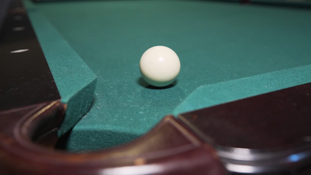 Jugador metiendo la bola 8 negra en la tronera de la esquina para ganar la partida de billar.