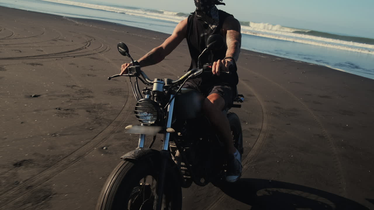 человек едет на мотоцикле по пляжу