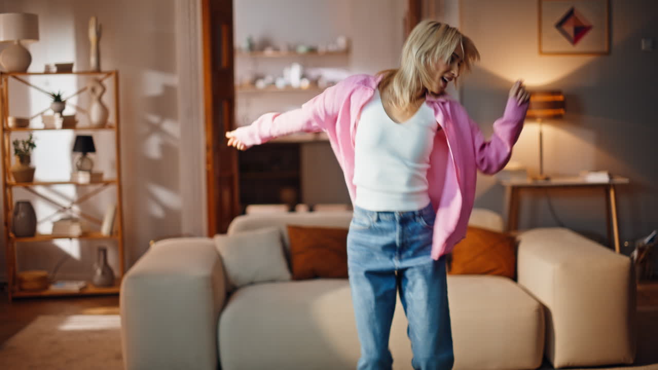 Homely woman dancing music feeling carefree at living room. Playful girl moving