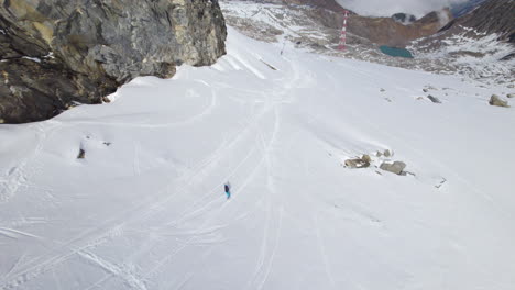 aerial top down shot of snowboarder skiing down the snowy slope of hill