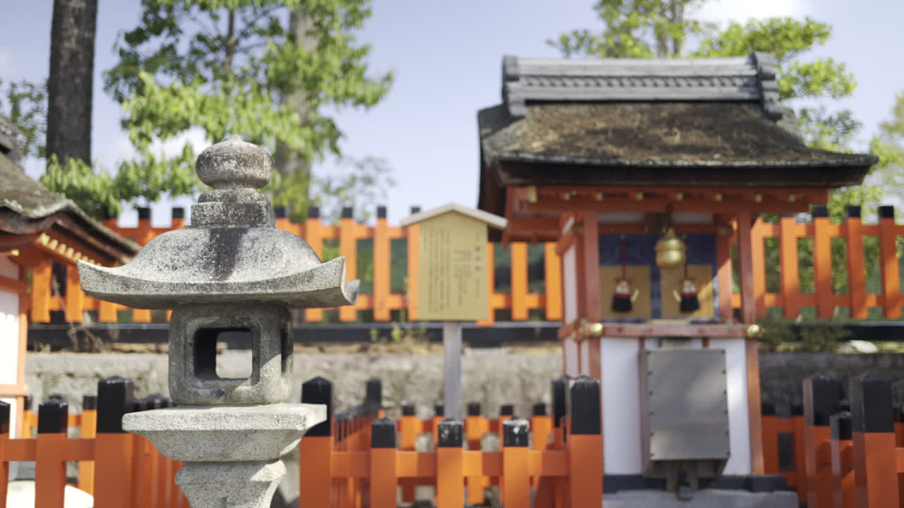 Fushimi-inari shrine nestled among trees, featuring orange fencing. Experience the serene atmosphere and traditional architecture unique to Japanese culture