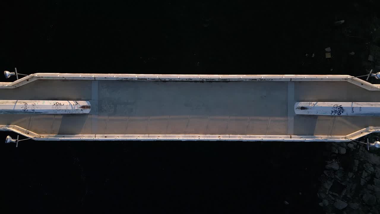 강의 다리와 그 위를 걷는 두 명의 보행자, 대칭 공중 샷