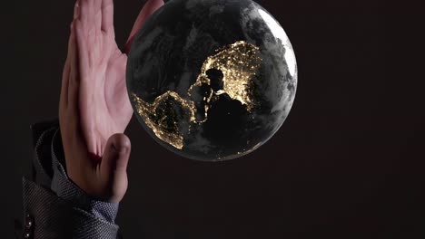 vertical del planeta tierra mundo globo iluminado por la noche girar por encima de la palma de la mano, la creación de los dioses religión robot concepto de inteligencia artificial