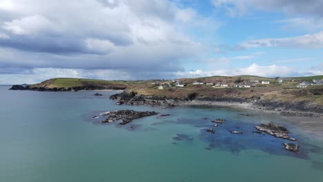 Eine-Luftaufnahme,-Die-Rückwärts-über-Grün-blaues-Wasser-Des-Ruhigen,-Sonnigen-Atlantiks,-Die-Schroffe-Küstenlinie-Und-Den-Dramatischen-Himmel-In-Irland-Fliegt