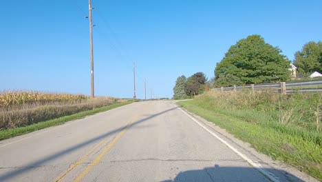 Pov-Pasando-Por-Campos-Maduros-De-Maíz,-Campos-De-Soja-Y-Corrales-En-La-Zona-Rural-De-Iowa-En-Un-Soleado-Día-De-Principios-De-Otoño