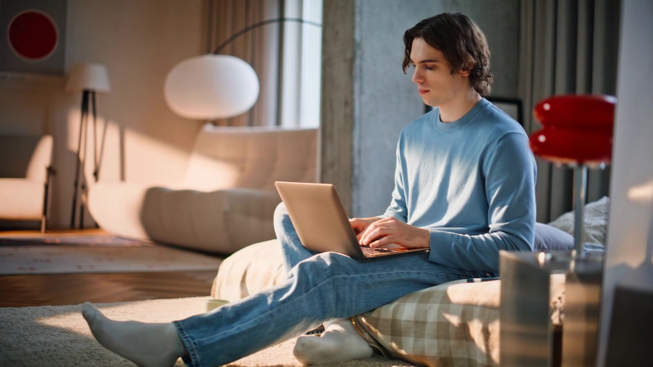 Uomo a casa che usa il laptop lavorando a letto in un weekend di sole. Imprenditore che riflette
