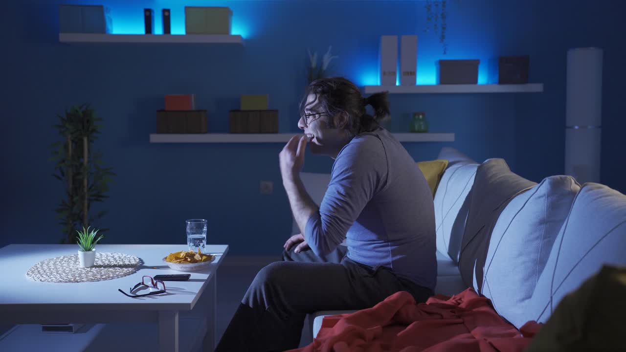 Homem engraçado assistindo a um programa de comédia e a rir alto
