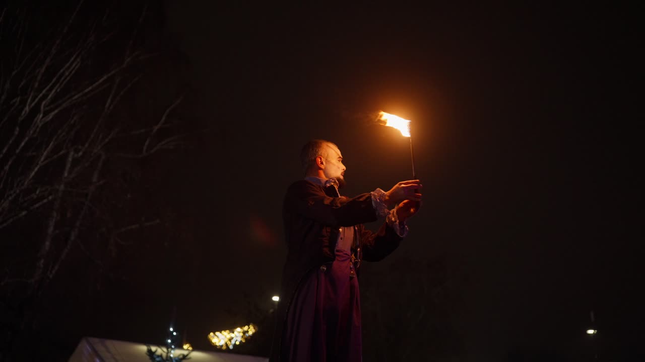 Spettacolo di fuoco al rallentatore con un'atmosfera drammatica e mistica da festival notturno.