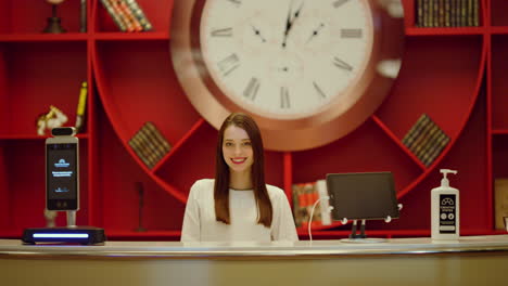 recepcionista mirando la cámara en el interior del hotel. mujer sonriendo en el espacio moderno.