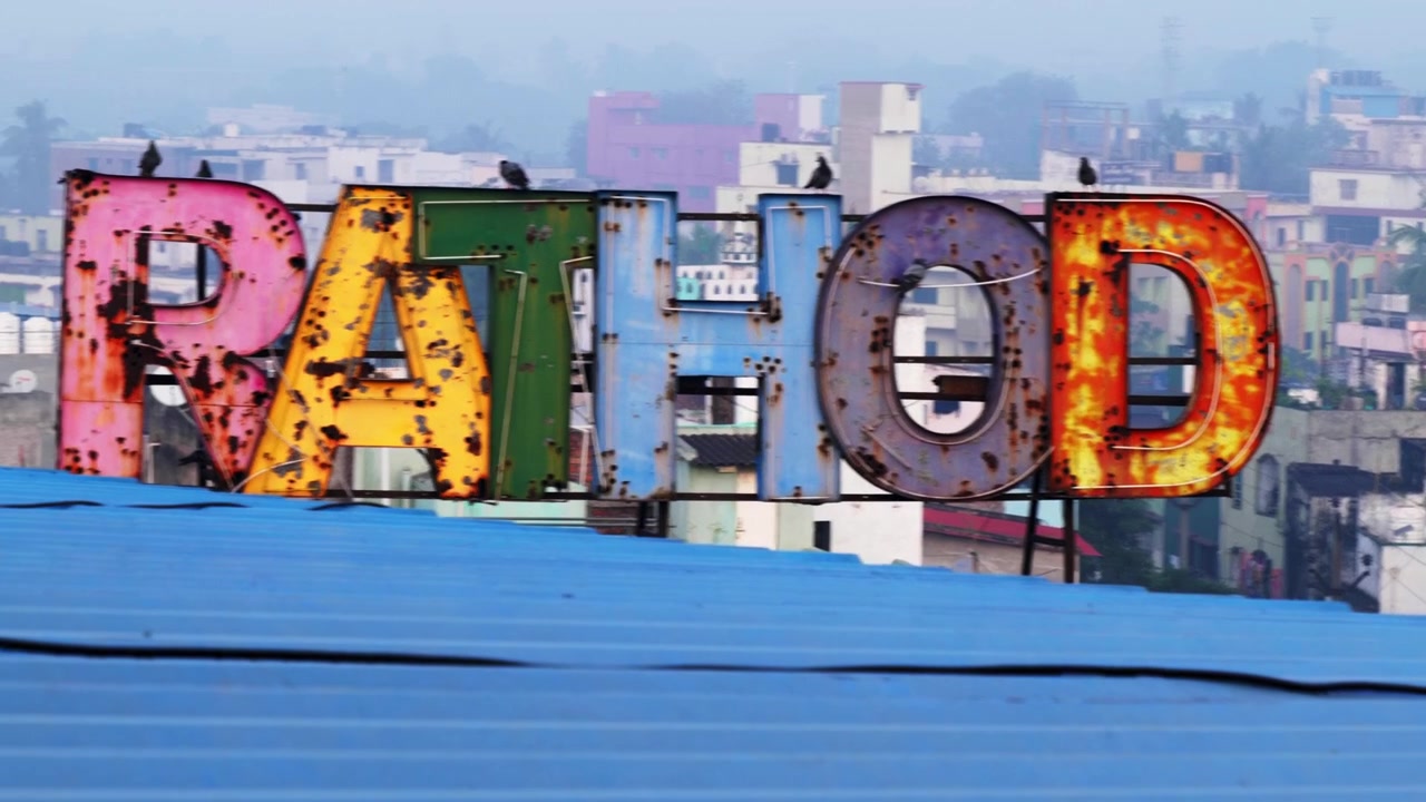 Piccioni posati su una vecchia insegna al neon arrugginita in cima a un edificio a Vizag 4K 30p.