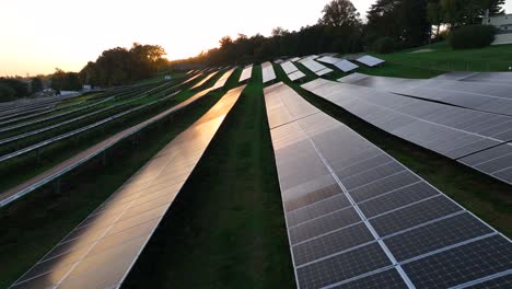 sunlight reflects on glossy solar panels during golden hour sunset