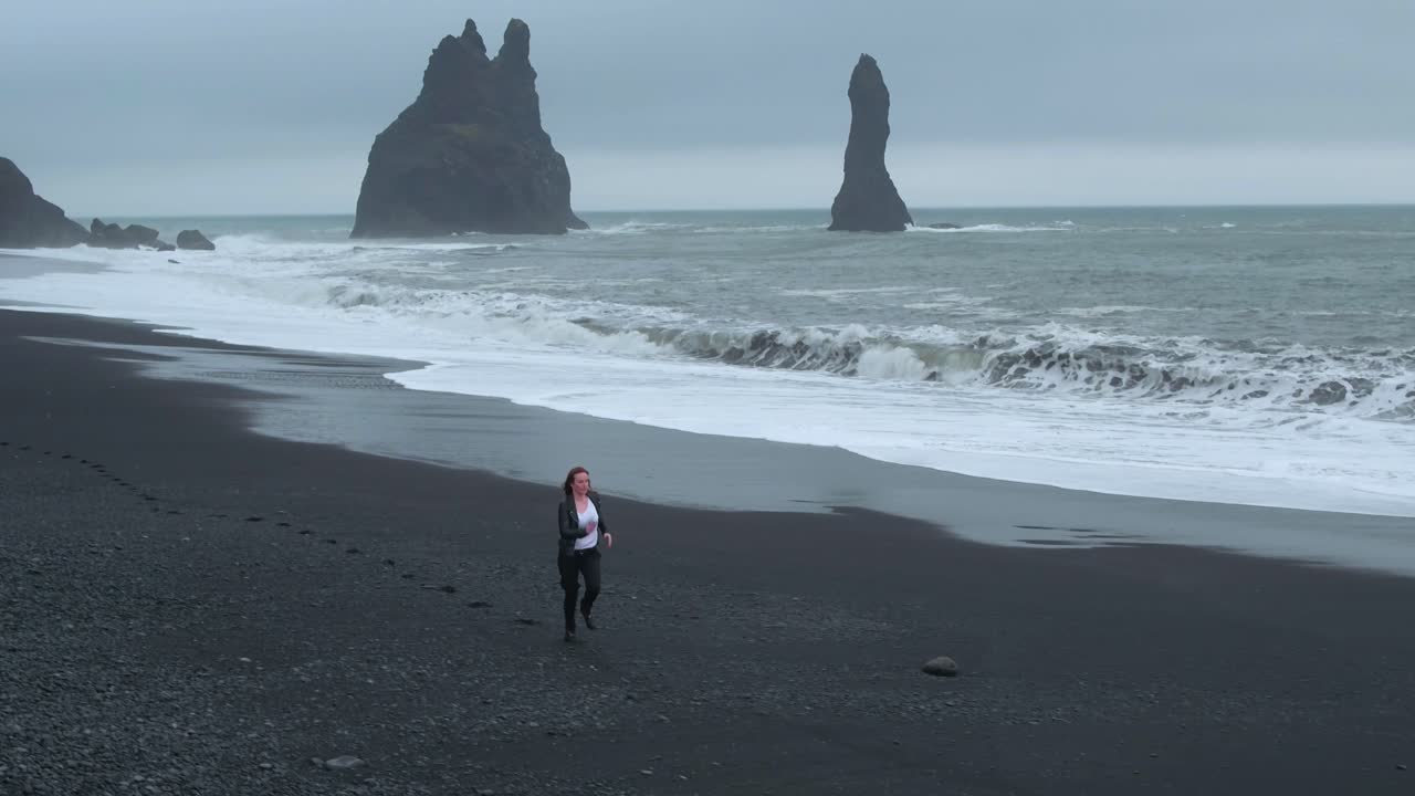 Woman Running on Black Sand Beach in Iceland