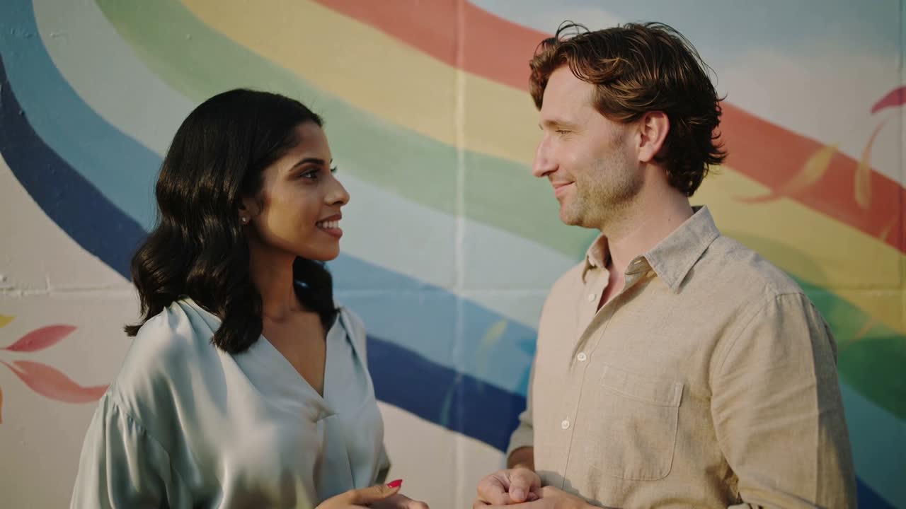 Woman speaking, gesturing after eye contact, man listening smiling by arc mural, red nails for ads