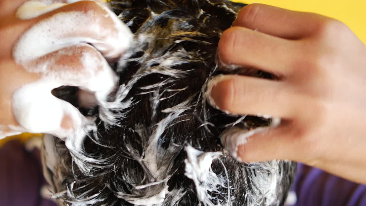 Mand vasker sit hår med shampoo