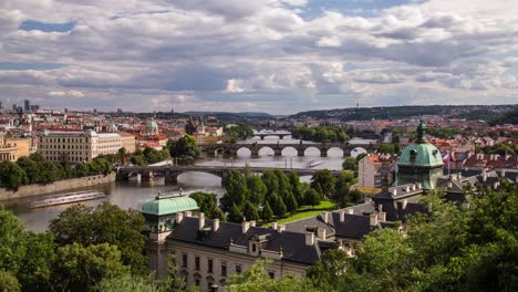 cloudy afternoon timelapse of the vltava river in prague, czech republic from letna park as clouds and boats pass by on a summer day with strakovska akademie and charles bridge in frame