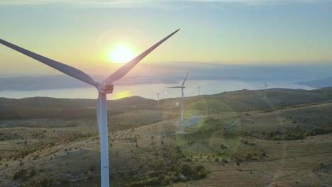 molino de viento aerogenerador puesta de sol aérea primer plano generador de suministro de energía limpia y sostenible, vista del paisaje marino no contaminado del océano