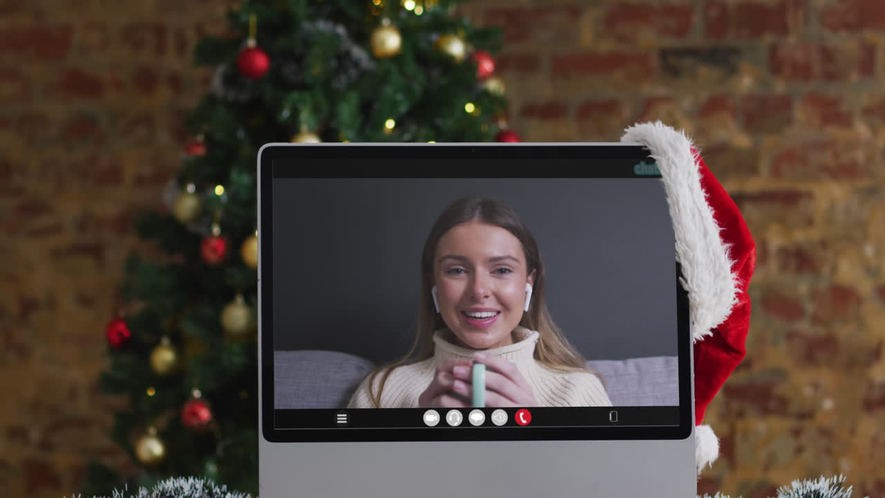 mujer caucásica feliz en videollamada en la computadora, con decoraciones de navidad y árbol