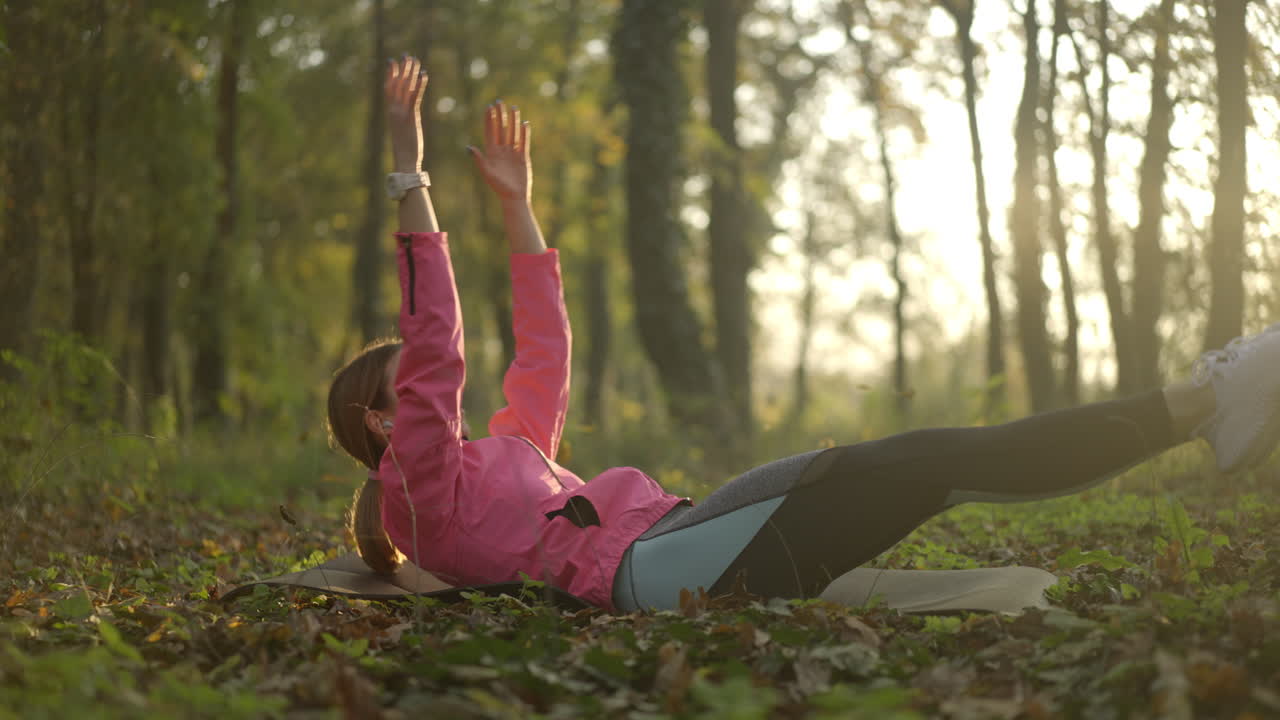 Woman doing core exercises in an autumn park