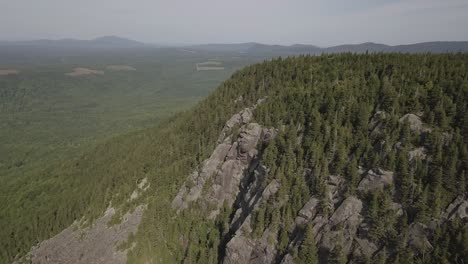 Toma-Aérea-De-Drones-Volando-Más-Allá-Del-Bosque-En-La-Ladera-De-La-Montaña