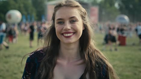 portrait of smiling young caucasian woman at music festival.