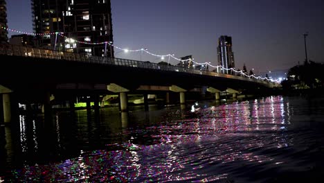 illuminated bridge reflecting on river at night