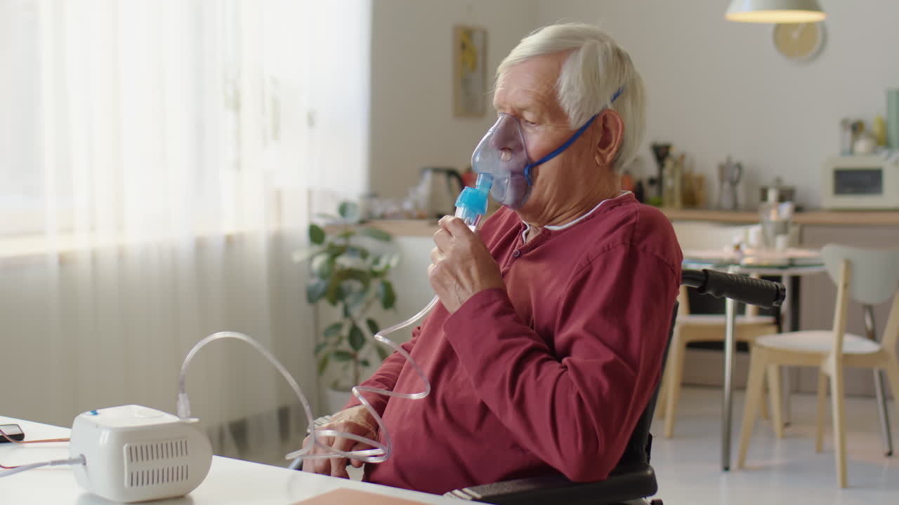Elderly Man in Wheelchair Doing Nebulizer Treatment
