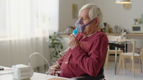 elderly man in wheelchair doing nebulizer treatment