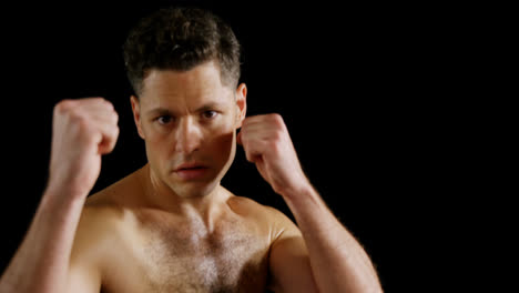 portrait of man boxing on black background