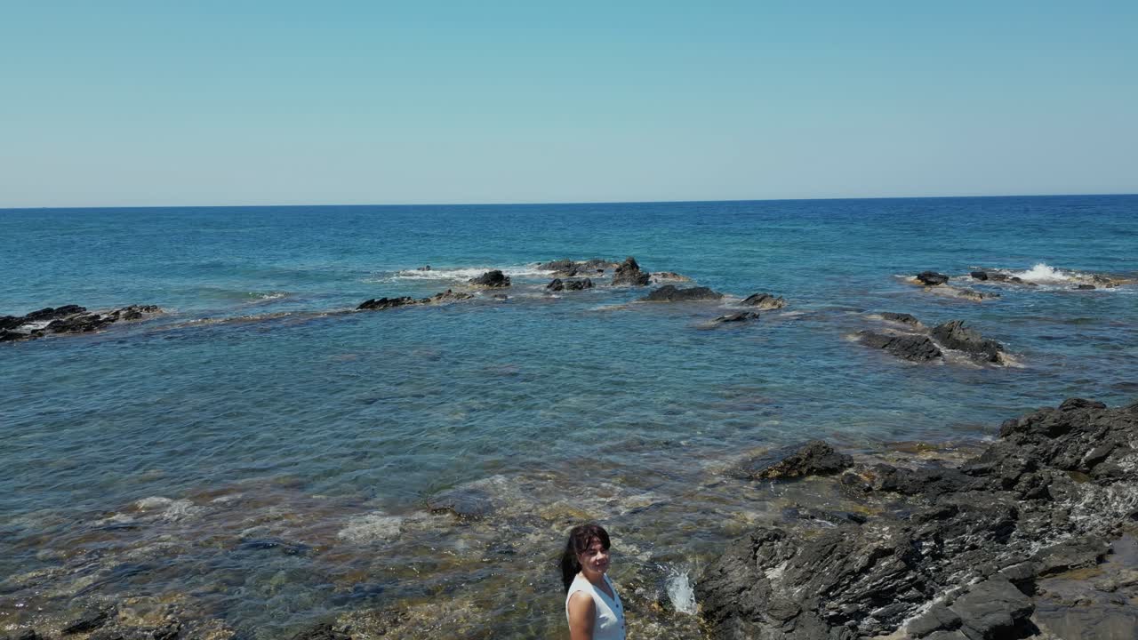 Tourist Woman On Rocky Beach In Chania, Crete, Greece - Drone Shot