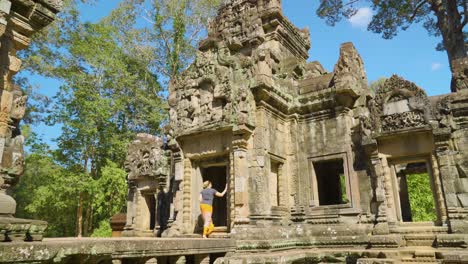 female traveling tourist walking between buildings at chau say tevoda temple in siem reap, cambodia