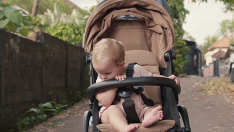 caucasian toddler in moving stroller outdoors