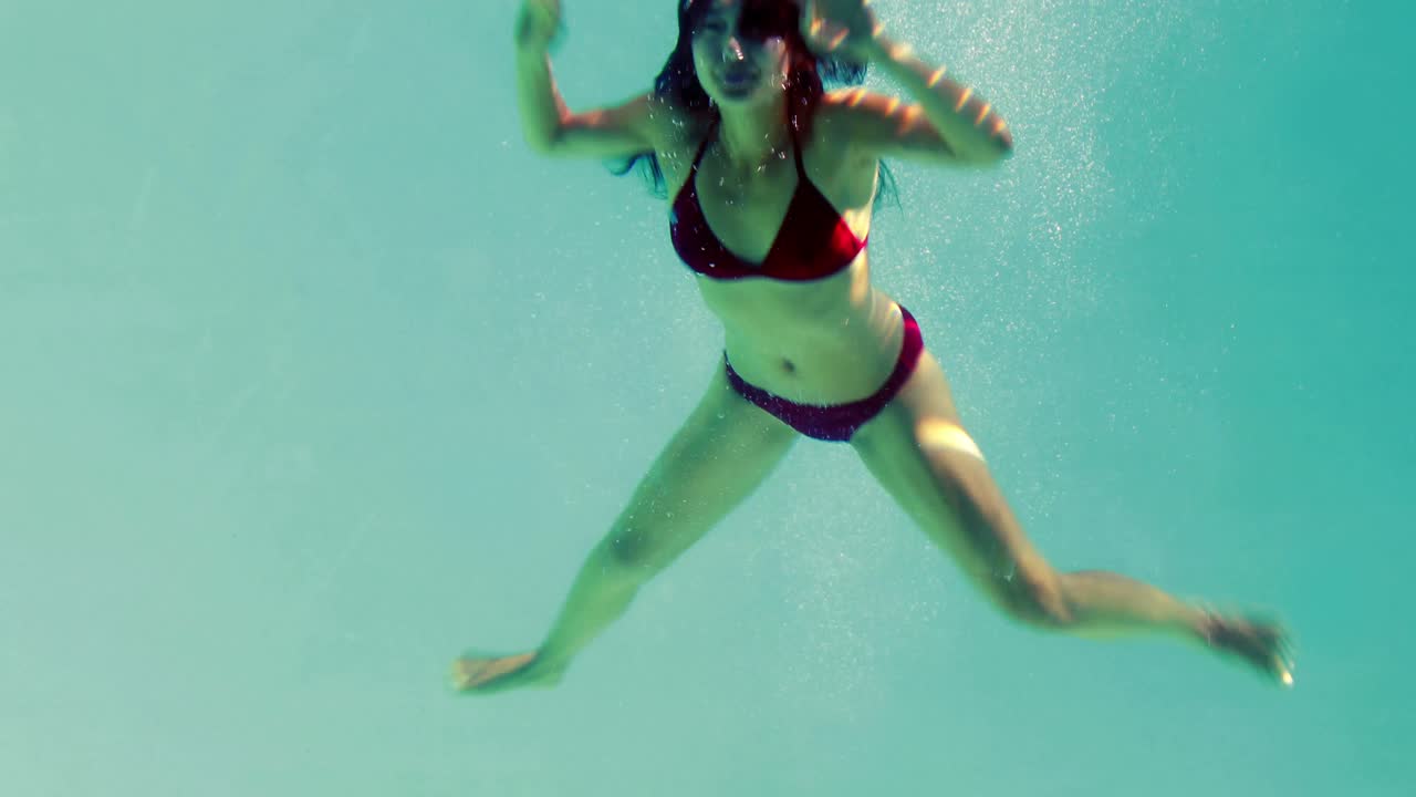 Bella brunetta che si tuffa in piscina.
