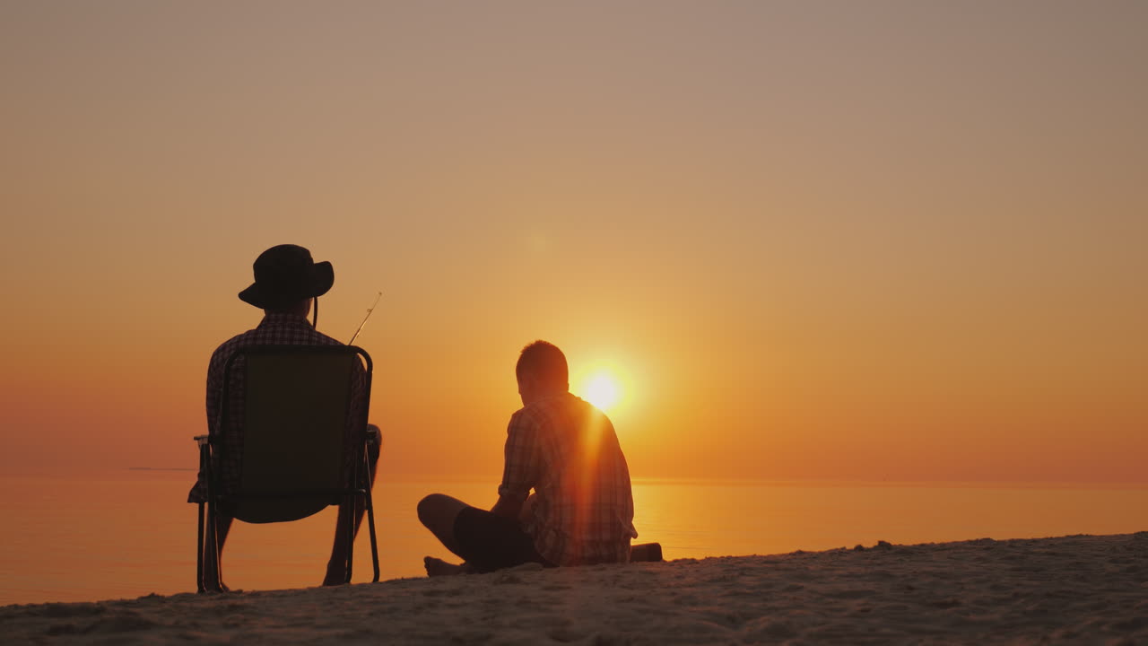 두 명의 십대가 야외에서 즐거운 시간을 보내고 있는 호숫가에서 낚시를 하고 있습니다.