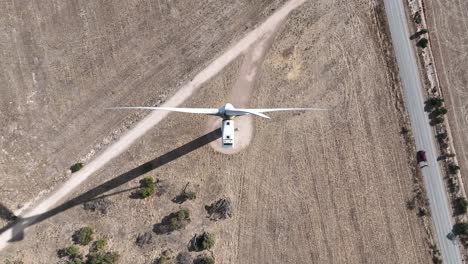 Stationary-top-down-drone-shot-of-spinning-wind-turbine