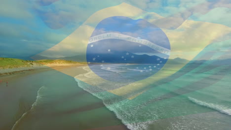 digitale zusammensetzung der schwingenden brasilianischen flagge gegen die luftansicht des strandes und der meereswellen