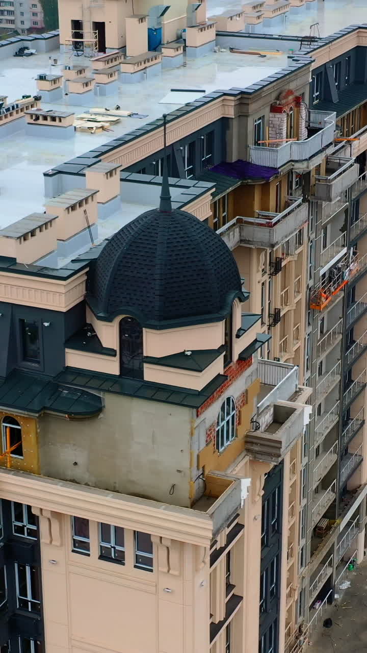 Construction of a tall building in the city. Modern block of flats builds in the city. New tower architecture with windows. Aerial view. Vertical video