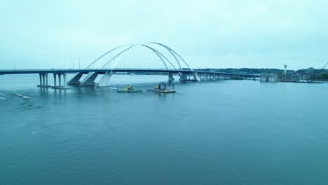 Aerial-of-construction-machineries-on-floating-docks-pontoon-on-mississippi-river-at-Centennial-Bridge-in-Davenport,-Iowa,-USA