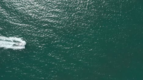 stationary-overhead-drone-shot-of-small-speed-boat-in-a-blue-sea