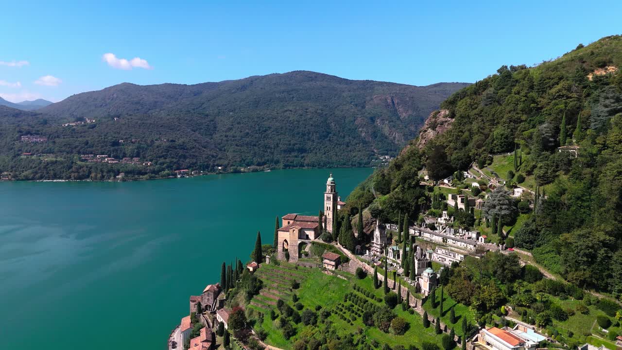 Drone view of church in Switzerland at Lake Lugano, Italy in background
