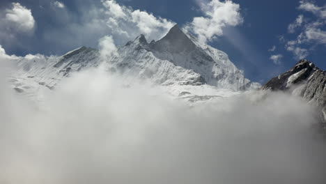 epic rotating drone shot of a foggy and snowy peak in the annapurna mountains, nepal