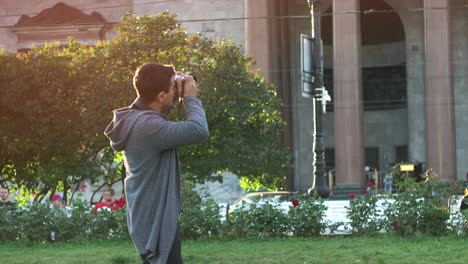 man taking picture in a city park