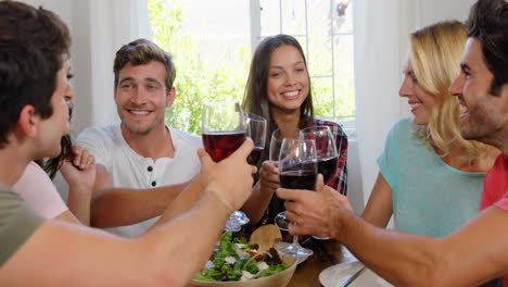 amigos felices comiendo un almuerzo saludable con vino