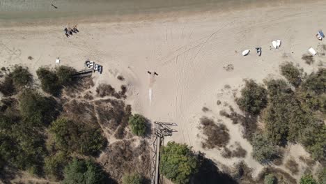 aerial view of sandy beach with boats and people