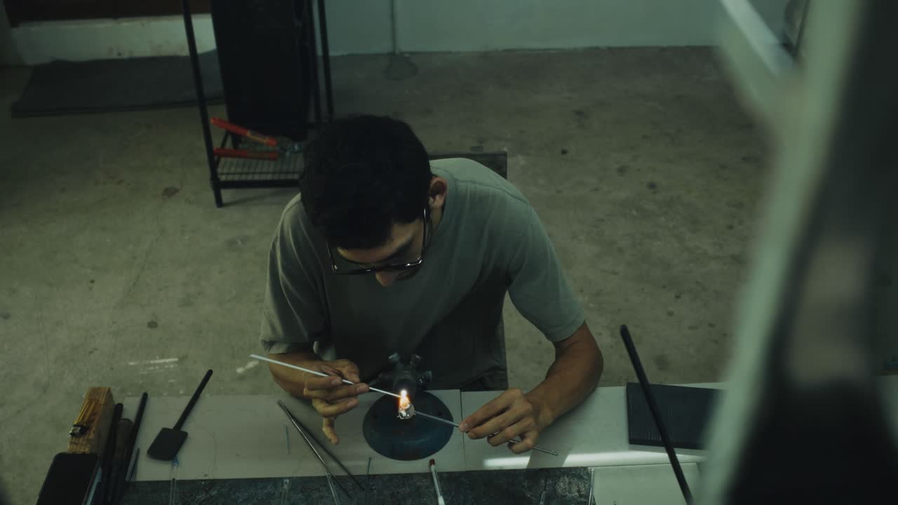 Un artista che soffia il vetro al lavoro
