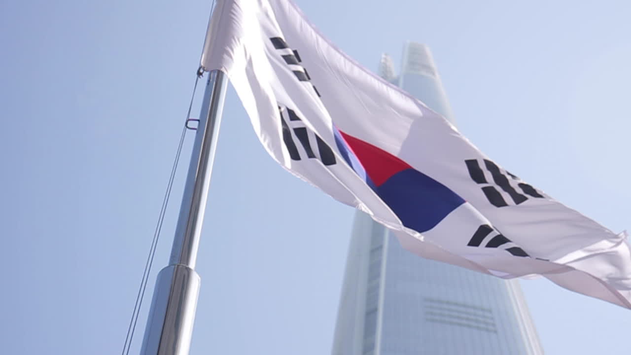 South Korean Flag Waving in Front of a Skyscraper