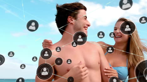 animación de la red de conexiones con iconos sobre una pareja caucásica abrazándose en la playa