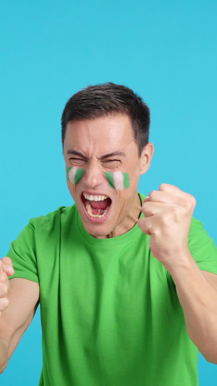 Man cheering for Nigeria screaming and waving a national flag