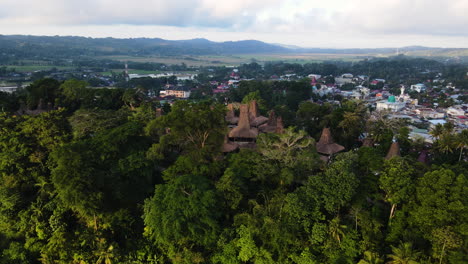 sumbanese traditional houses over tropical mountains near weekacura lagoon in west sumba, indonesia