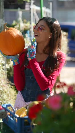 woman holding a pumpkin at a farmers market